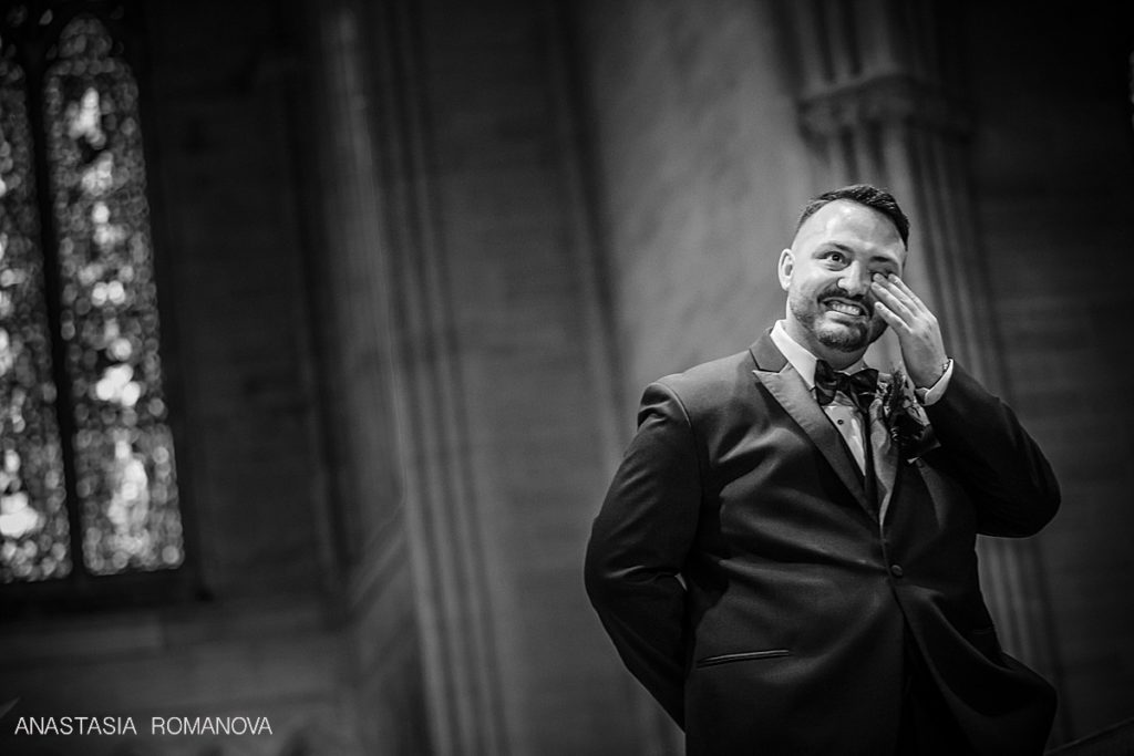 groom is crying seeing the bride for the first time walking down the aisle at Bryn Athyn Cathedral wedding ceremony