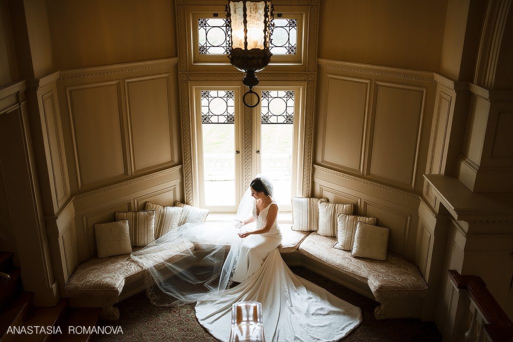 Stunning bride sitting by a huge window at Cairnwood Estate