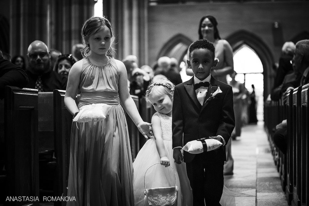 flower girl and a ring bearer are walking down the aisle