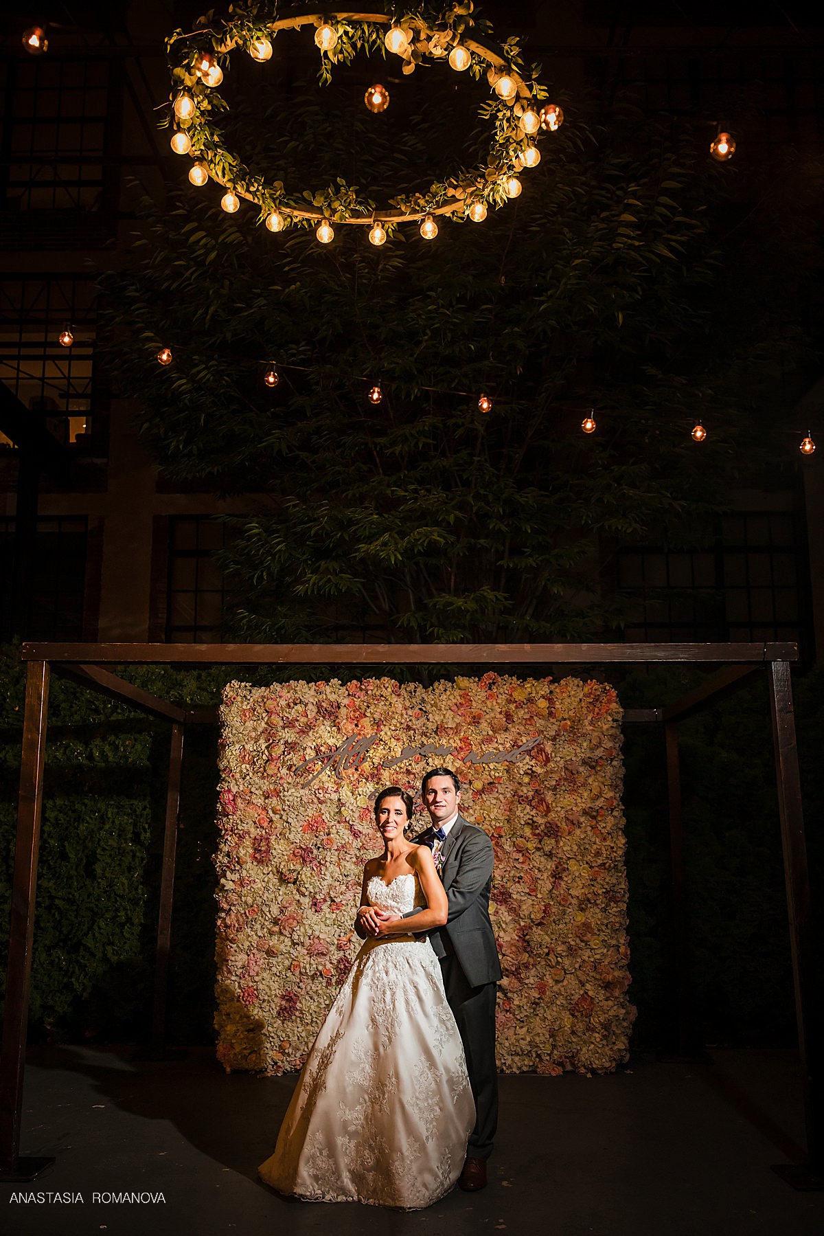 Bride and groom in front of a flower wall at Cescaphe outdoor wedding in Philadelphia
