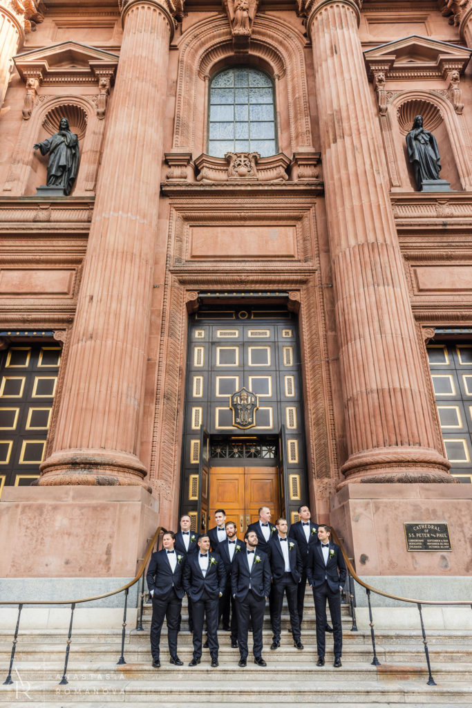 Groomsmen on the steps in front of the Cathedral Basilica os Saints Peter and Paul before wedding ceremony