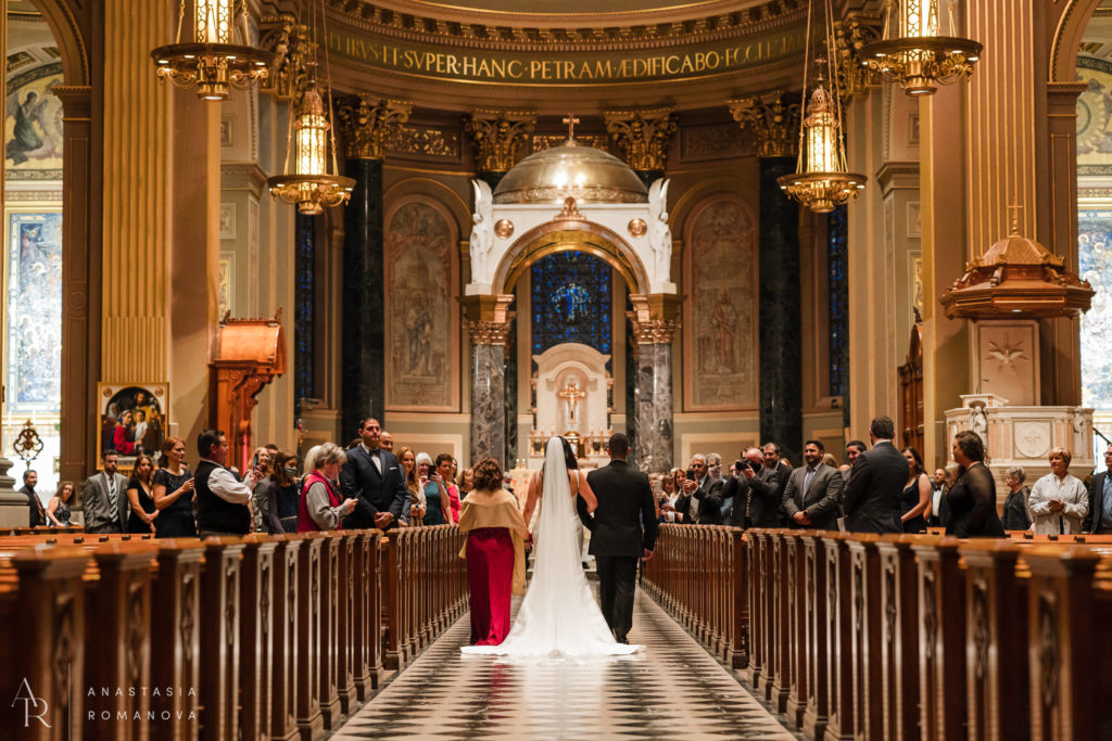 Back view of the bride walking down the aisle at Cathedral Basilica of Saints Pater and Paul