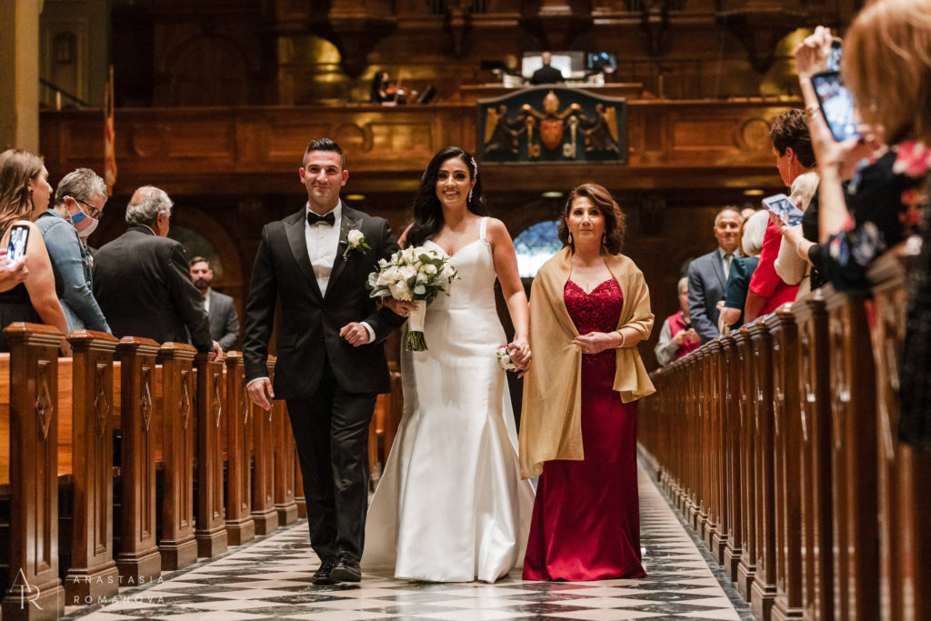 Bride an long train wedding gown walks down the aisle at Cathedral Basilica of Saint Peter and Paul
