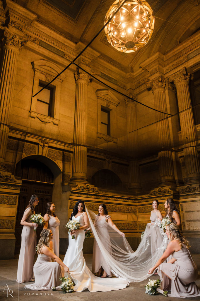 Bride surrounded by her bridesmaids under the archway at Philadelphia city hall  